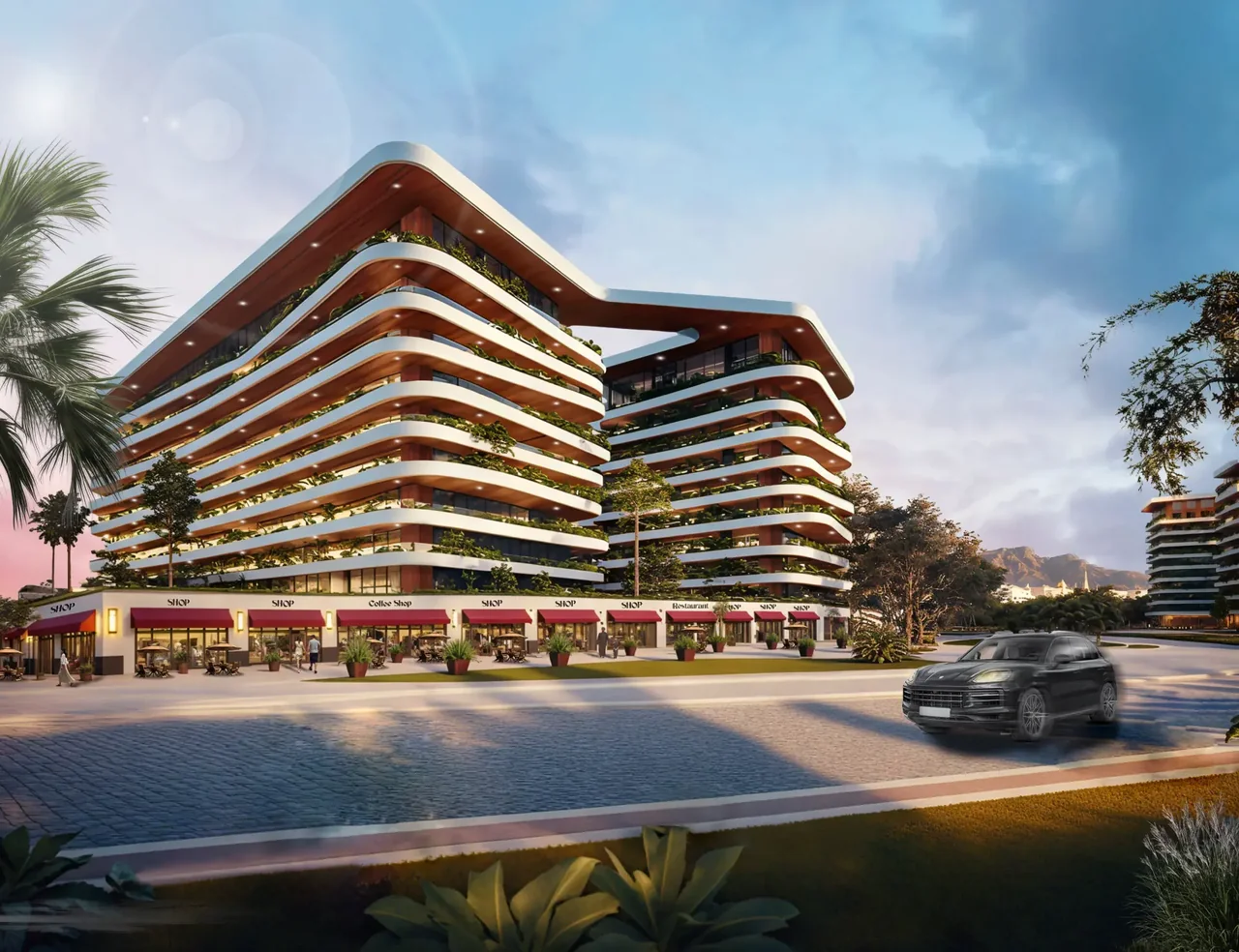 Uptown Muscat residences with curved balconies and boulevard shops at sunset